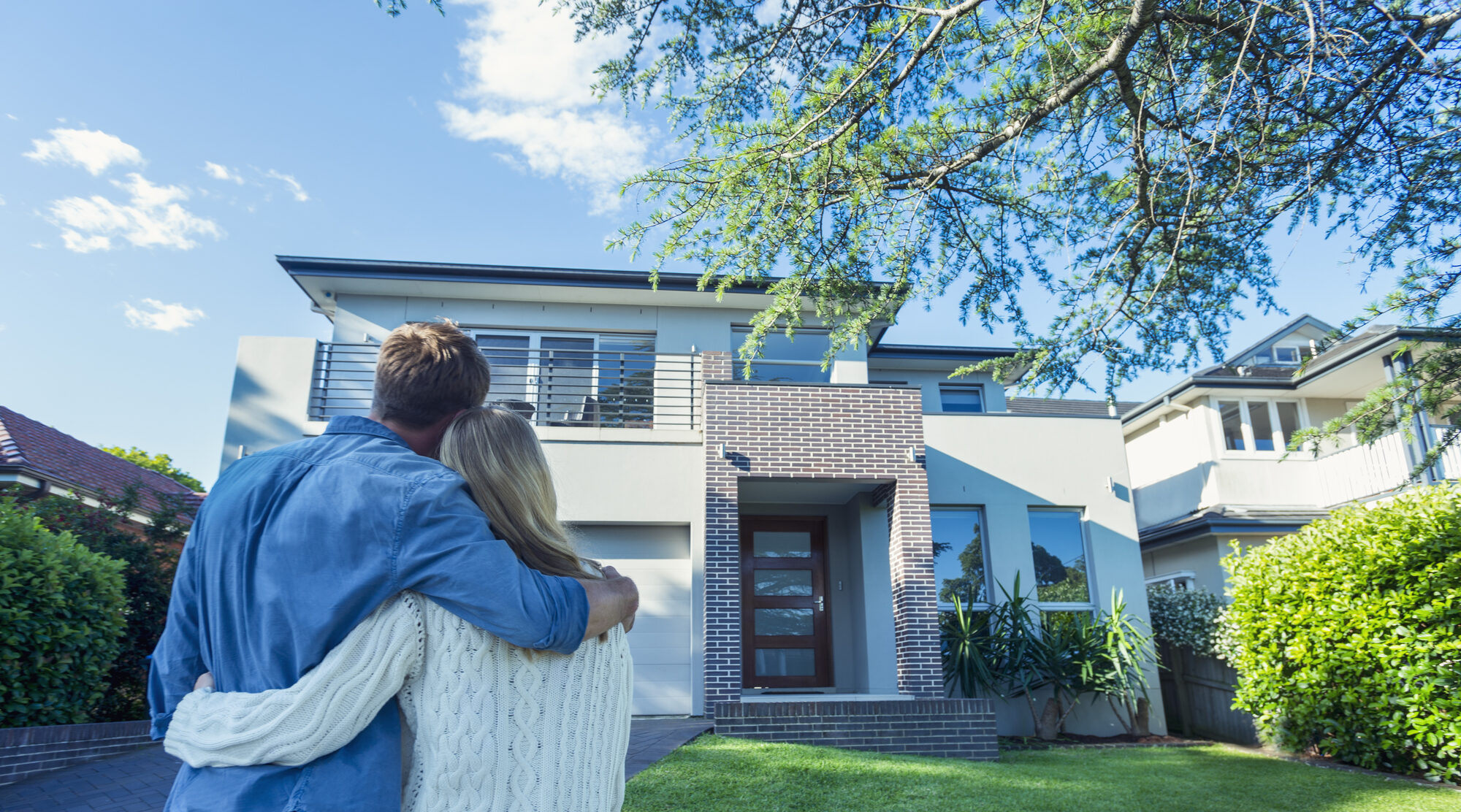 Couple standing in front of their new home